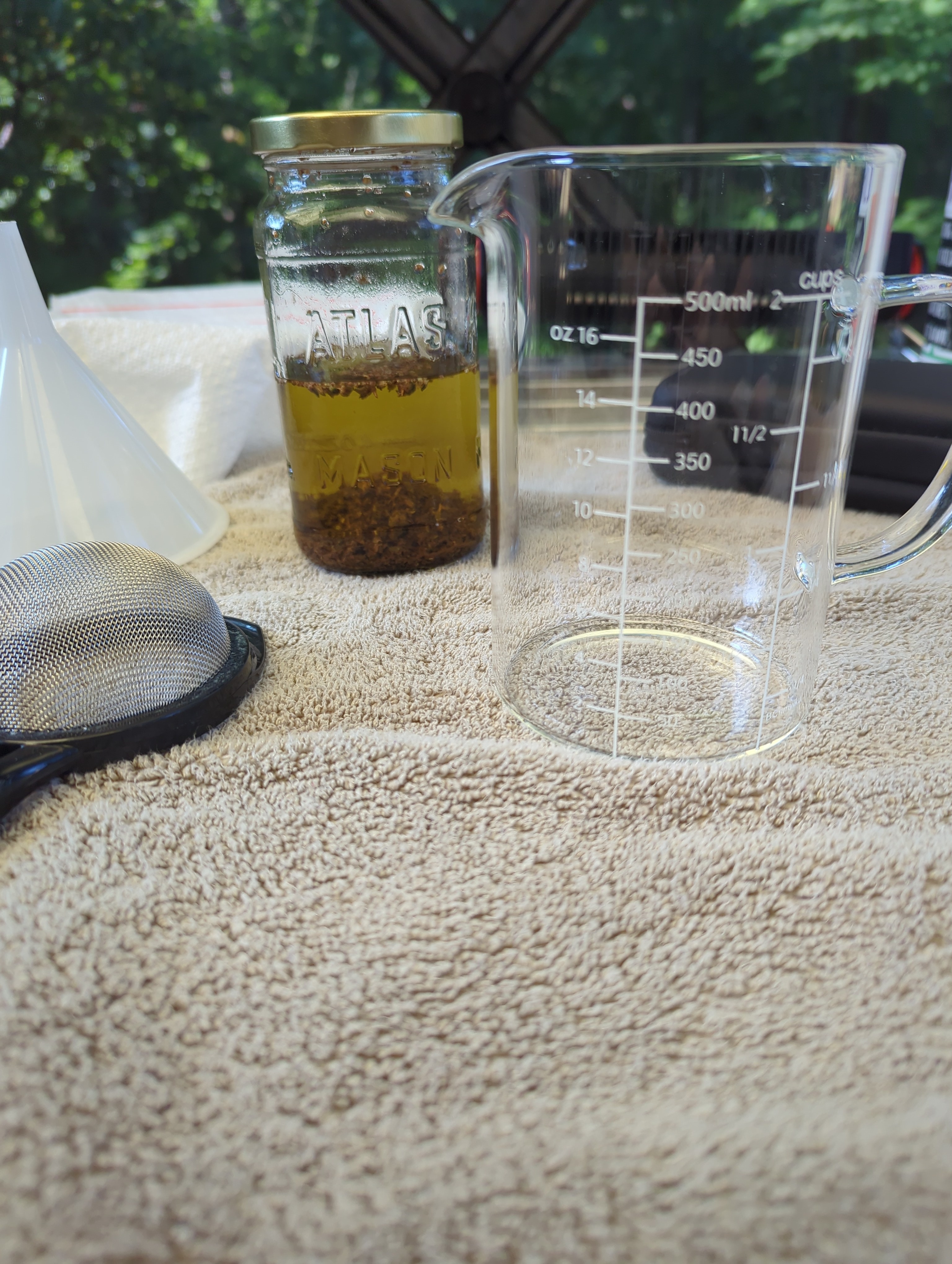 a glass jar containing everclear and cannabis sits next to a beaker